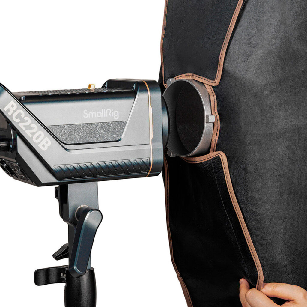 SmallRig-4200-5 Studiovalo on asennettu jalustalle mustan ja ruskean SmallRig 4200 LA-R30120 Softbox Stripin viereen, ja käsi säätää softboxia.