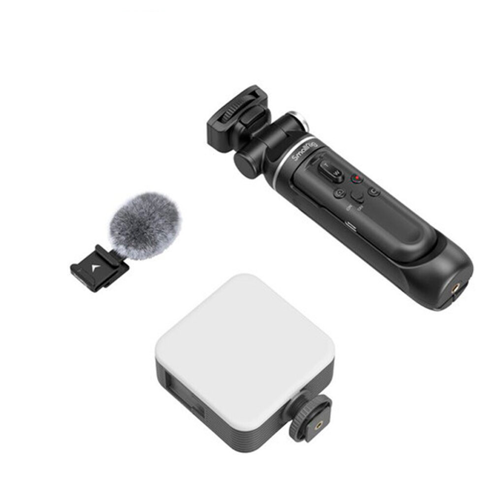 SmallRig-4258-6 SmallRig 4258 Vlogging Tripod Kit Sony ZV-E1:lle, ZV-E10:lle, ZV-1:lle ja ZV-1F:lle sisältää mustan käsikäyttöisen kardaanin, harmaan karvaisen mikrofonin ja valkoisen suorakulmaisen laitteen, jossa on kiinnitysnuppi, kaikki kuvassa valkoisella pohjalla.