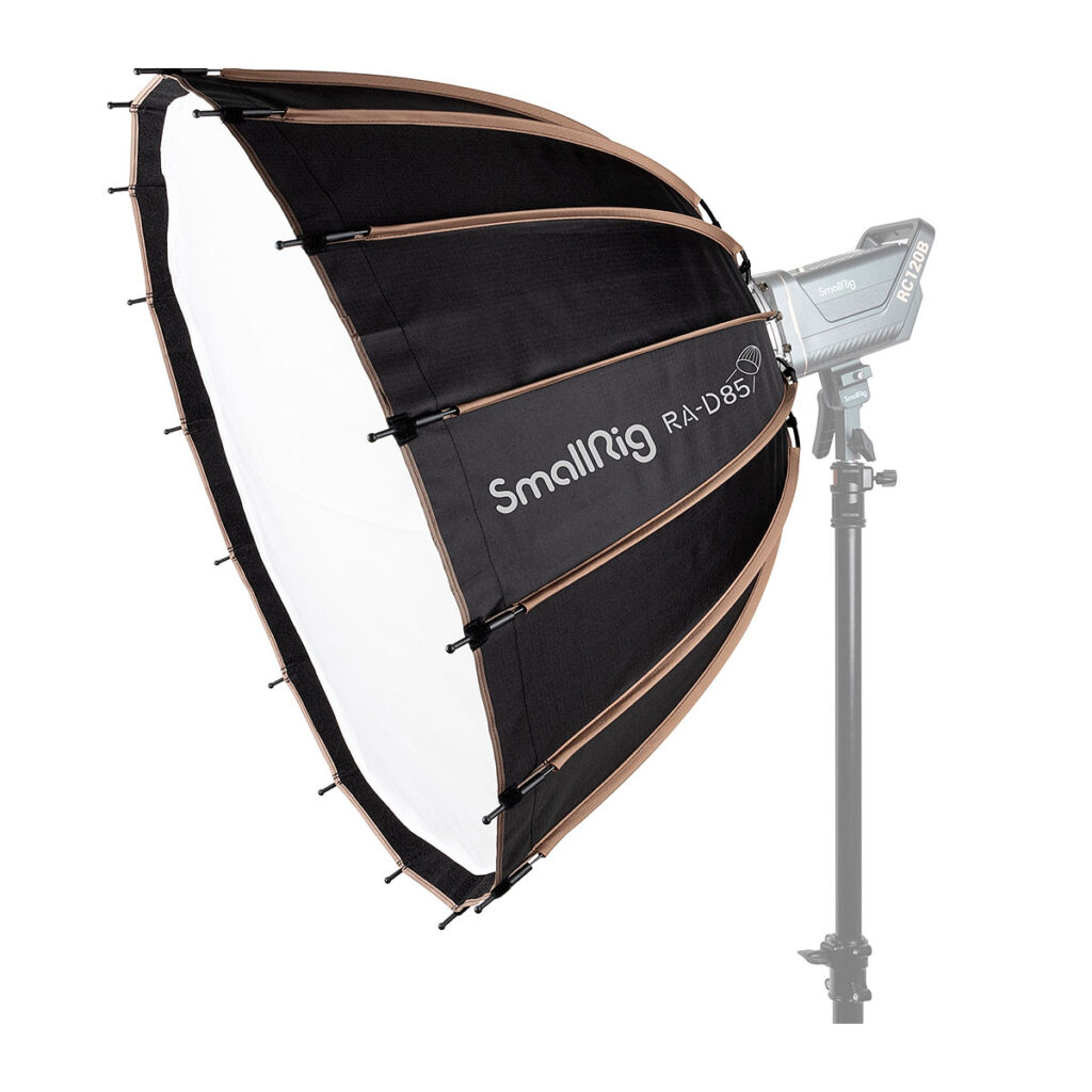SmallRig_RA-D85_Softbox_3586_001 Mustavalkoinen SmallRig 3586 RA-D85 Parabolic Softbox on asennettu valotelineeseen ja sen taakse on kiinnitetty studiovalo valkoista taustaa vasten.