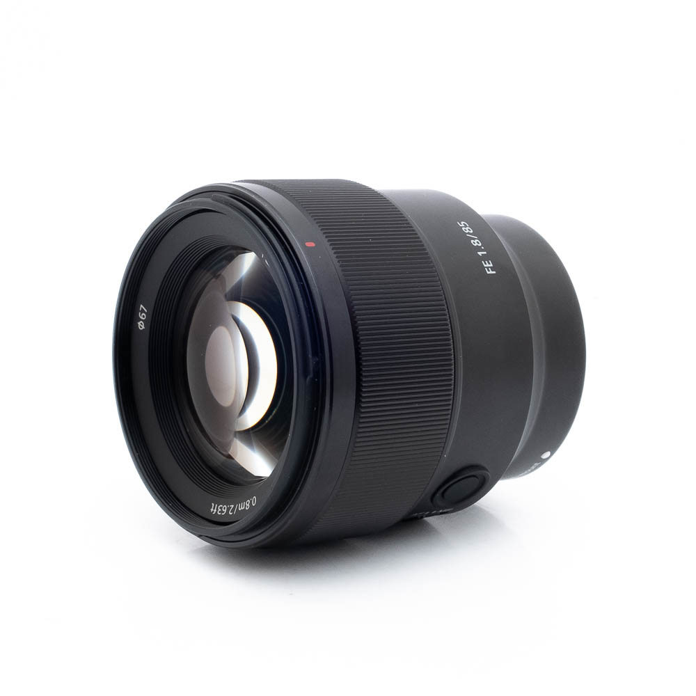 Sony FE 85mm f18 Sony FE 85mm f/1.8 (Kunto K5) - Käytetty musta kameraobjektiivi, jossa on leveä etulasi, AF/MF-kytkin ja "FE 85mm F1.8" -merkinnät valkoisella pohjalla.