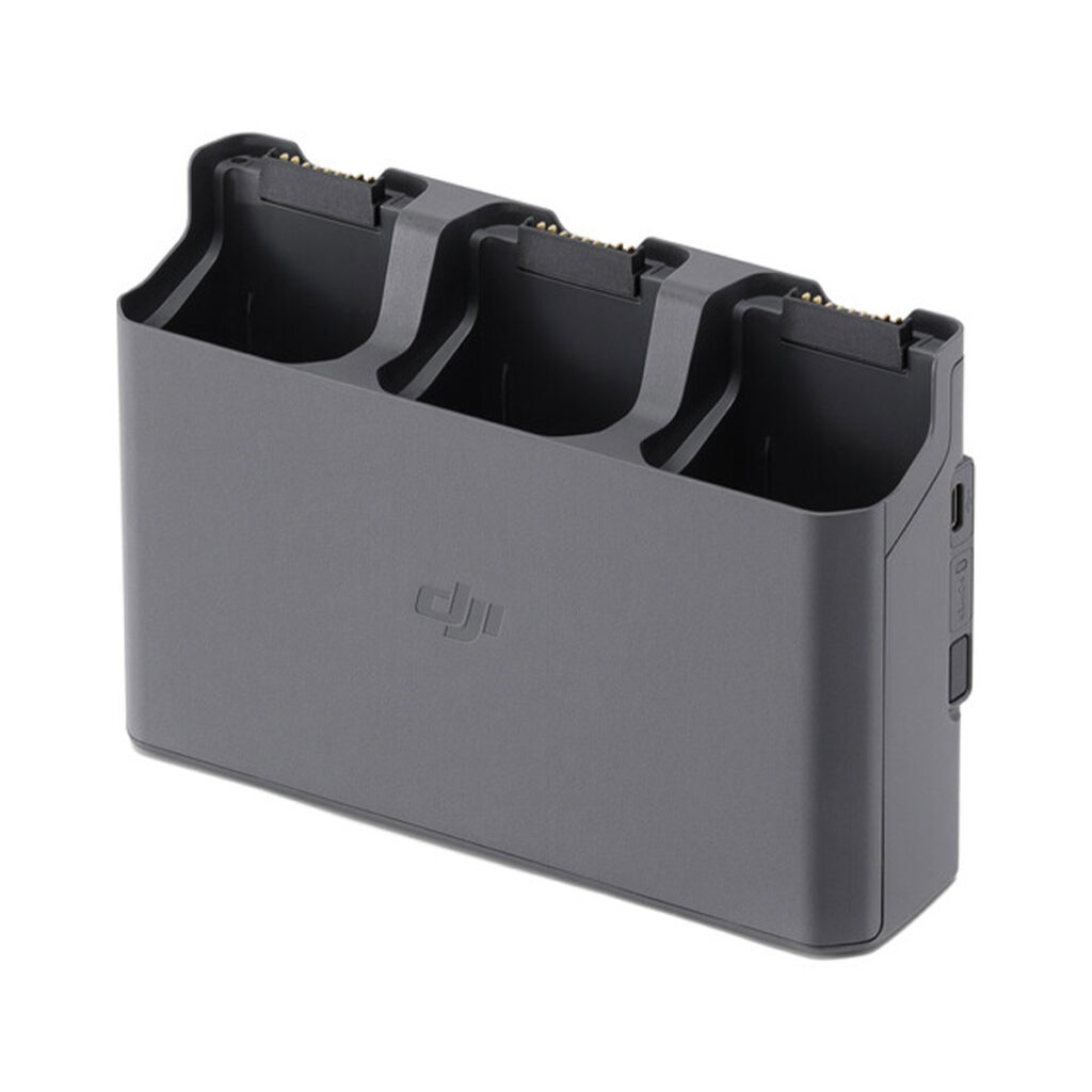 DJI Air 3 Charging Hub DJI Air 3 Battery Charging Hub -lataustelakka on harmaa latauskeskitin, jossa on kolme aukkoa, joissa jokaisessa on liitäntänastat akuille, ja sivupainike helppoa käyttöä varten.