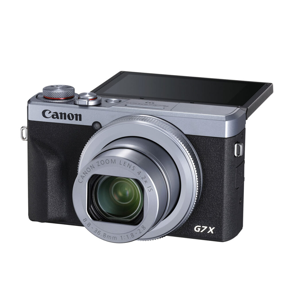 Canon PowerShot G7 X Mark III -kompaktikamerassa on hopeanvärinen ja musta runko, laajennettu zoom-objektiivi ja ylöspäin kääntyvä LCD-näyttö.