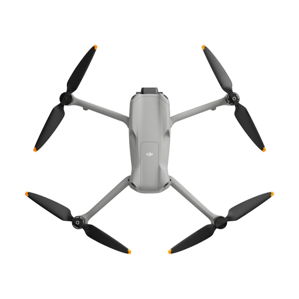 dji_air_3_rc-n2_01 DJI Air 3 (DJI RC-N2) -lennokki, jossa on tyylikäs harmaa runko, jossa on neljä mustaa oranssilla värillä varustettua potkuria, näkyy ylhäältä päin valkoisella pohjalla, mikä korostaa sen modernia muotoilua.