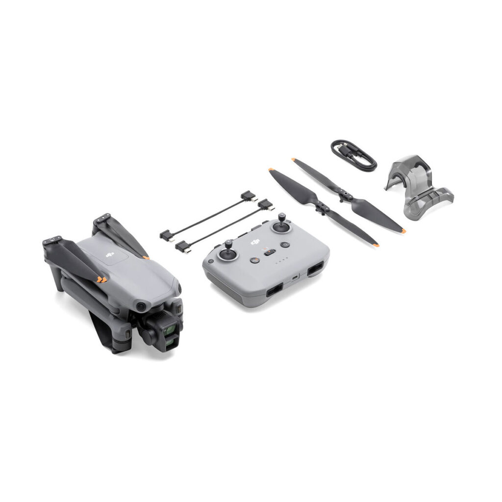 dji_air_3_rc-n2_04 DJI Air 3 (DJI RC-N2) -lennokki, kauko-ohjain, kaksi potkuria, kaapelit, lataustarvikkeet ja irrotettava kameran suojus on esitetty taitettuna valkoisella pohjalla.