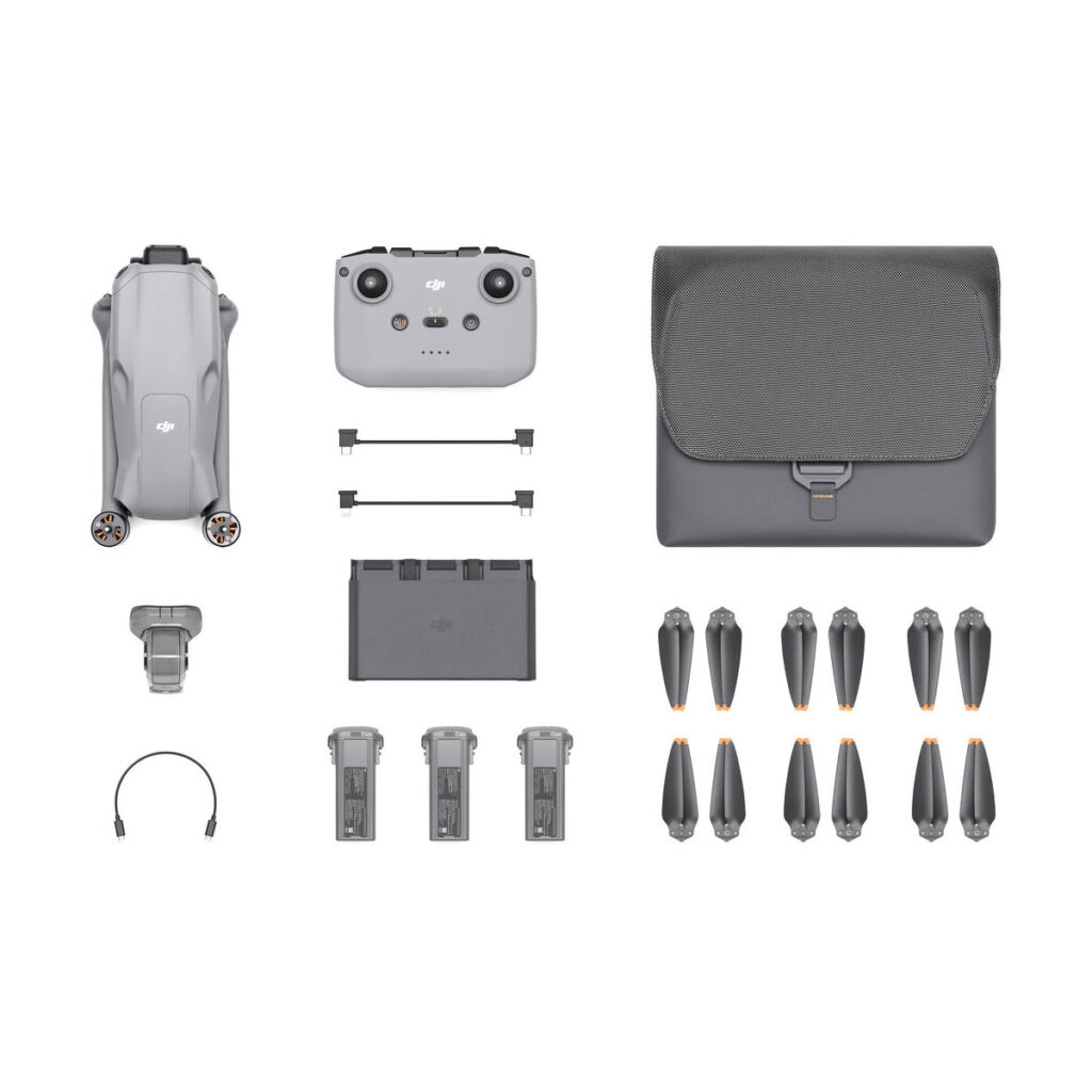 dji_air_3_rc-n2_flymore_01 DJI Air 3 (DJI RC-N2) Fly More Combo ylhäältä alaspäin, jossa näkyy kokoontaitettu lennokki, kauko-ohjain, kantolaukku, kolme akkua, potkurit, latausnapa, kaapelit, varaosat ja pienet tarvikkeet siististi järjestettyinä valkoiselle taustalle.