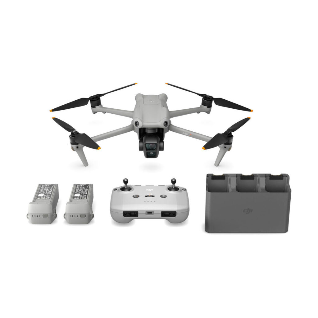 dji_air_3_rc-n2_flymore_03 Harmaa DJI Air 3 (DJI RC-N2) Fly More Combo -lennokki, jossa on kamera, kaukosäädin, kaksi akkua ja latauskeskus siististi järjestettynä valkoisella pohjalla.