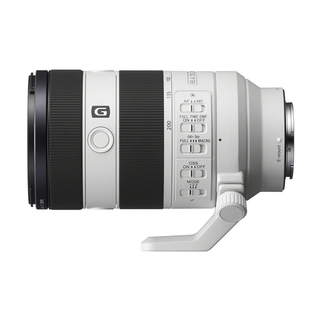 sony_70-200_f4_03 Sivukuva valkoisesta Sony FE 70-200 f/4 G OSS II -objektiivin telezoom-objektiivista, jossa on erilaisia kytkimiä, hallintalaitteita, jalustakiinnitysjalka ja Sony G -logo objektiivin rungossa.