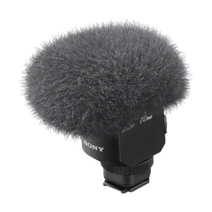 sony_ecm_m1_03 Close-up of a Sony ECM-M1 microphone with a fluffy grey windscreen to reduce wind noise during audio recording, and a black base with clearly marked controls.
