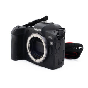 Canon EOS R (SC 63000) - Käytetty peilitön kamerarunko, musta, kuvassa ilman objektiivia, objektiivin kiinnitys ja kenno; osa kameran hihnasta on näkyvissä.