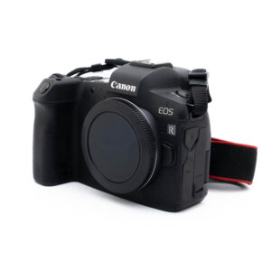 Canon EOS R (SC 63000) - Käytetty peilitön digikamera, musta, pelkkä runko, näkyy edestä ja oikealta puolelta kuvioidulla kahvalla ja punaisella reunustetulla kaulahihnalla.