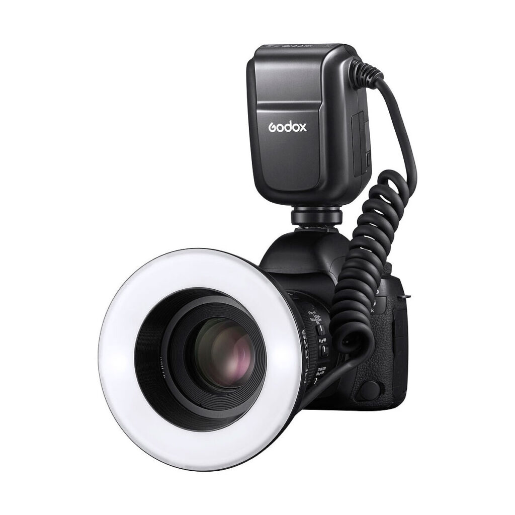 Godox_MF-R76_004 A digital camera equipped with a Godox MF-R76C TTL Macro Ring Flash for Canon and an external Godox AD300 Pro flash unit connected by a twisted pair cable is photographed against a white background.