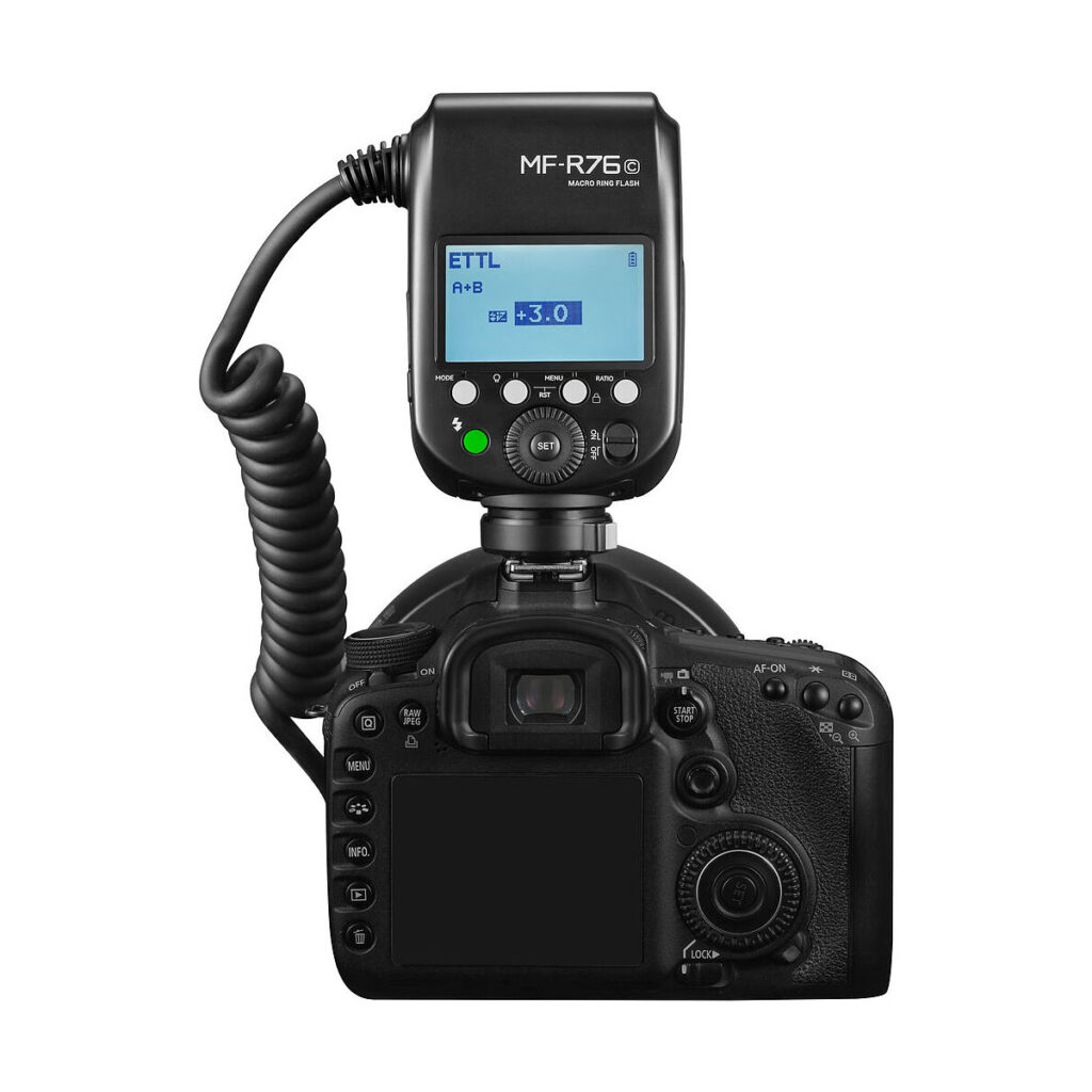 Godox_MF-R76_005 A digital DSLR camera with Godox AD300 Pro and Godox MF-R76C TTL Macro Ring Flash for Canon mounted on top; the flash shows the settings on the LCD screen and is connected with a twisted pair cable.