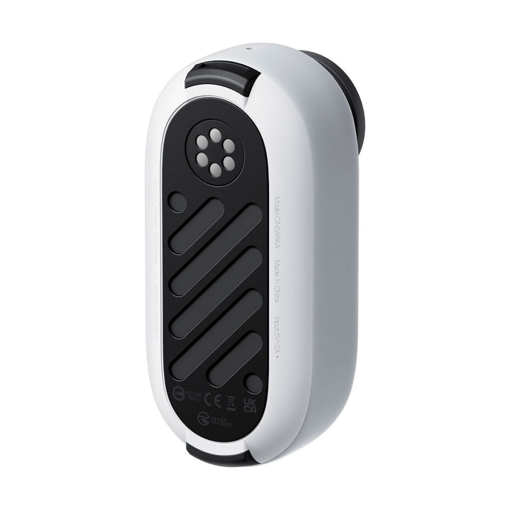 Insta360_Go_3_006 Insta360 Go 3 (64 Gt) on kompakti, soikean muotoinen, valko-musta elektroniikkalaite, jossa on pyöreä tuuletusaukko ja vinot harjanteet mustalla puolella, kuvassa kulmassa valkoista taustaa vasten.