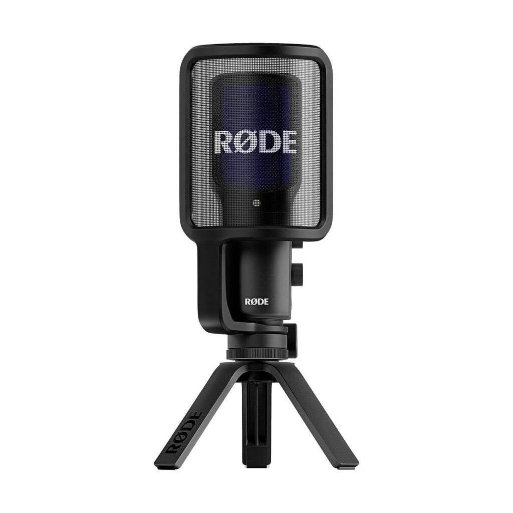 Rode_Video_NT-USB+_002 Rode Videomic ME-C, musta mikrofoni, jossa on verkkomallinen ponnahdussuodatin, on asennettu pieneen kolmijalkaiseen jalustaan ja näytetään valkoista taustaa vasten.