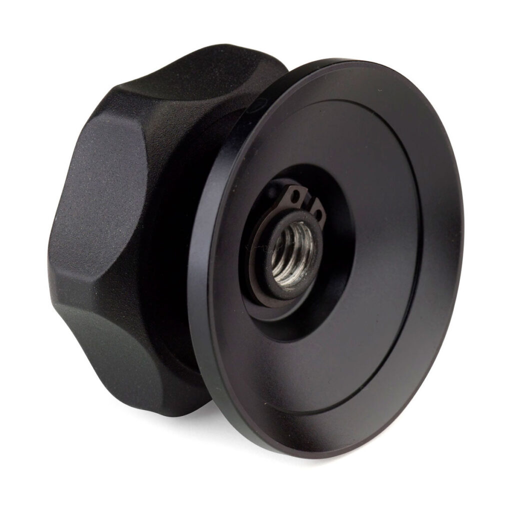 Benro_BL75S_003 Lähikuva Benro 75mm Half Ball Adapterista, mustasta, pyöreästä metallisesta nupista, jossa on kuvioitu kahva ja keskellä kierteitetty reikä, joka on suunniteltu varusteiden varaosaksi.