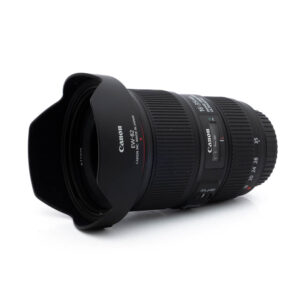 Canon EF 16-35mm f/4 L IS USM - Käytetty zoom-objektiivi, jossa on vastavalosuoja, valkoisella pohjalla vinossa, jotta sekä etuelementti että sivut näkyvät.