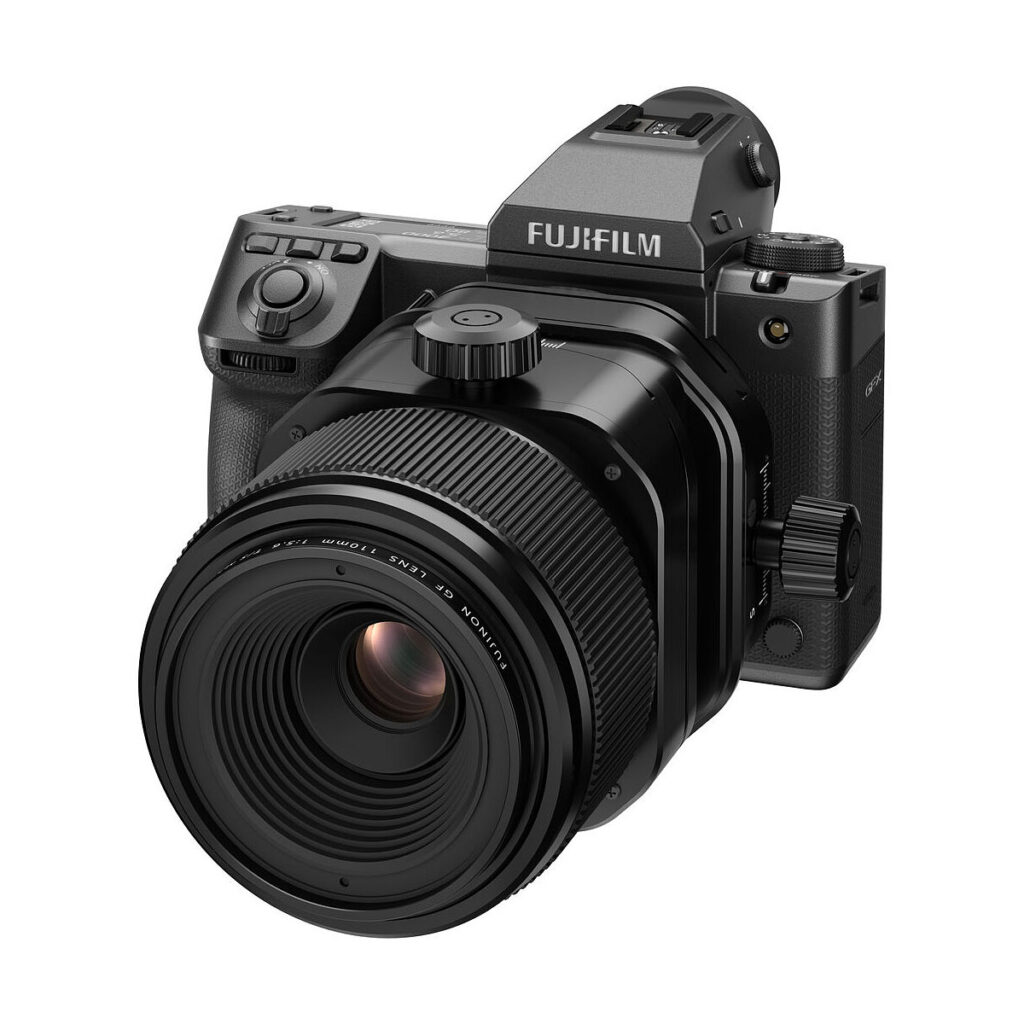 FujiFilm_Fujinon_110mm_GF_TS_004 Musta Fujifilm-digitaalikamera, jossa on Fujinon GF 110mm f/5.6 T/S -objektiivi ja jossa on erilaisia painikkeita ja valintakiekkoja, näkyy valkoisella taustalla.