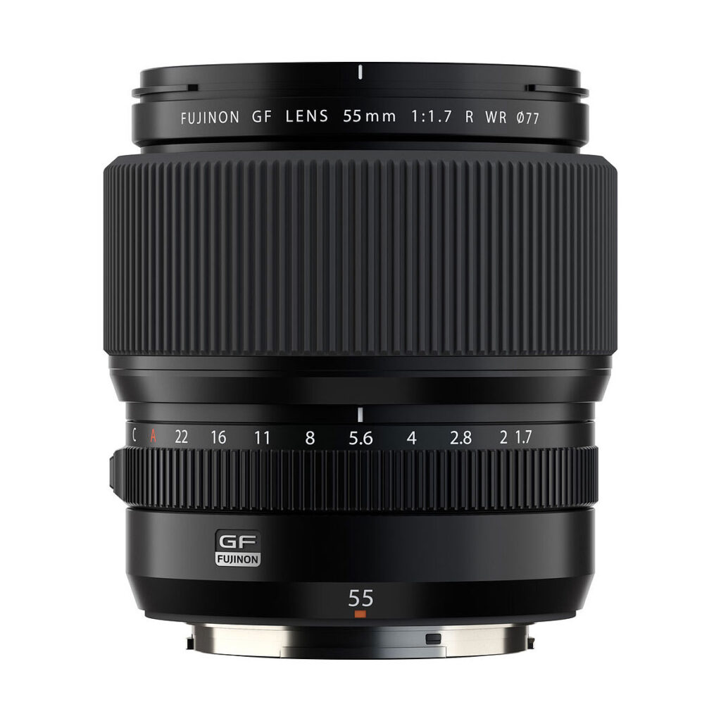 A Fujifilm Fujinon GF 55mm f/1.7 R WR -objektiivi seisoo pystyssä valkoista taustaa vasten. Mustassa objektiivissa on näkyvät tarkennus- ja aukorengas, joissa on merkinnät teknisistä tiedoista.