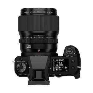 Ylhäältä katsottuna musta Fujifilm-kamera, johon on kiinnitetty Fujinon GF 55mm f/1.7 R WR -objektiivi, jossa on säätöpyörät, painikkeet ja digitaalinen näyttö, joka näyttää kameran asetukset.
