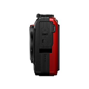 Olympus_TG-7_PUN_004 Sivunäkymä OM System Tough TG-7 -kompaktikamera, punainen, osoittaa sen suljettu HDMI ja USB-portit selkeät tarrat, kuvioitu kahva, ja osa objektiivin näkyvissä. Kamera on punainen ja musta valkoista taustaa vasten.