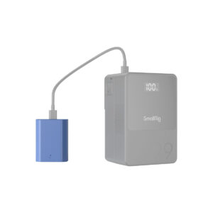 SmallRig_2465_005 Sininen SmallRig 4265 USB-C ladattava kamera-akku NP-FZ100 on yhdistetty harmaalla kaapelilla harmaaseen suorakulmaiseen SmallRig-virtapankkiin, jonka digitaalisessa näytössä näkyy 100 %. Molemmat on asetettu valkoista taustaa vasten.