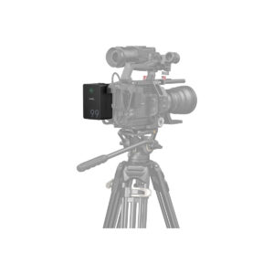 SmallRig_4292_006 Close-up of a professional video camera on a tripod with a SmallRig 4292 VB99 Pro mini V-Mount battery attached to the side. The camera and tripod appear partially faded.