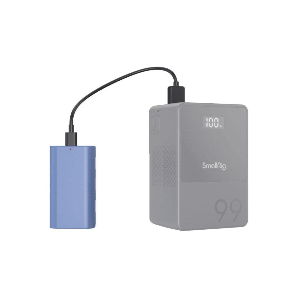 SmallRig_4331_006 Sininen kannettava laite on liitetty mustalla kaapelilla harmaaseen SmallRig 4331 USB-C ladattavaan kameran akkuun NP-F550, jonka alakulmaan on kaiverrettu "99". Laitteen digitaalisessa näytössä näkyy "100L".