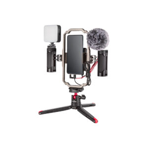 Smallrig_3384_001 SmallRig 3384 Professional Vlogging Kit sisältää älypuhelimen, joka on kiinnitetty suorakulmaisella kehyksellä varustettuun jalustaan, LED-valon vasemmalla puolella ja ulkoisen mikrofonin, jossa on karvainen tuulisuoja oikealla puolella.