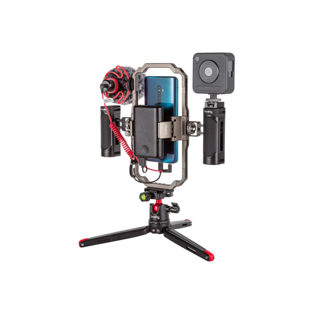 Smallrig_3384_002 SmallRig 3384 Professional Vlogging Kit, joka sisältää älypuhelimen kaksoiskahvalla varustetulla jalustalla, jossa on ulkoinen mikrofoni, LED-valo ja akkupaketti, on asennettu kompaktille jalustalle.