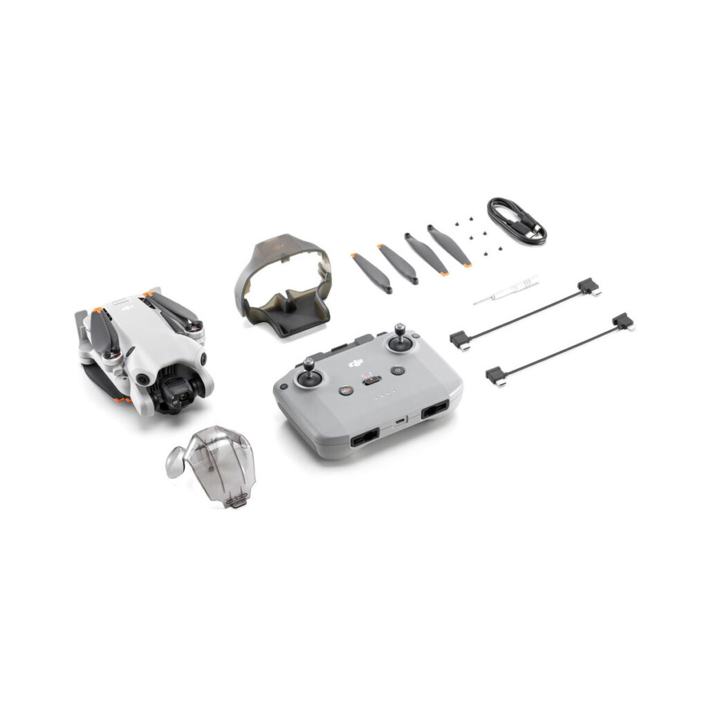 mini_4_pro_rc-n2_02 DJI Mini 4 Pro -lennokkipakkaus sisältää kokoontaitetun lennokin, kauko-ohjaimen, akkulaturin, potkurit, kaapelit, ruuvit ja potkurisuojat siististi järjestettynä valkoiselle taustalle.