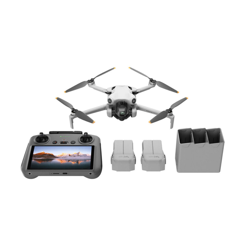 mini_4_pro_rc2_flymore_02 DJI Mini 4 Pro Fly More Combo + RC2 ohjain -lennokki näkyy kauko-ohjaimella, jossa on sisäänrakennettu näyttö, kaksi akkua ja kolmipaikkainen latauskeskitin valkoisella pohjalla.