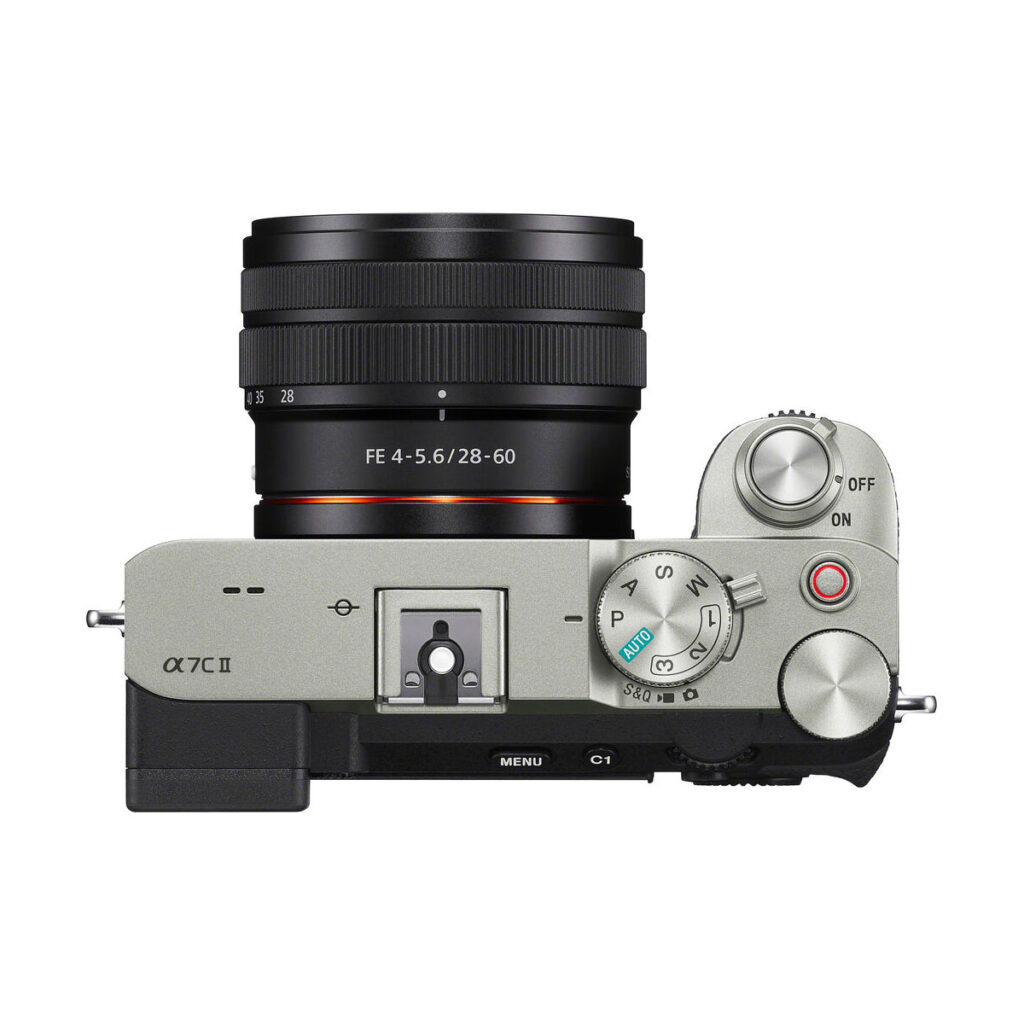 sony_a7c_ii_28-60mm_01 Top photo of the Sony A7C II + 28-60mm f/4-5.6 OSS, showing the silver camera with control dials, buttons and power switch on the right. Includes €100 Cashback offer.
