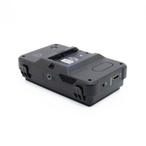 Atomos Shinobi-1 Fujinon GF 50mm f/3.5 R LM WR (sis.ALV24%) - Käytetty objektiivi on esitetty valkoisella taustalla, ja se on sijoitettu niin, että sen sivut ja takaosa näkyvät, ja siinä on erilaisia portteja, kuten HDMI- ja DC-sisääntulo, sekä akkupaikka päällä.