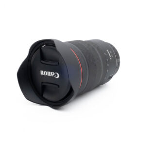 Fujinon GF 50mm f/3.5 R LM WR (sis.ALV24%) - Käytetty objektiivi, johon on kiinnitetty huppu ja suojus, makaa kyljellään valkoista taustaa vasten.