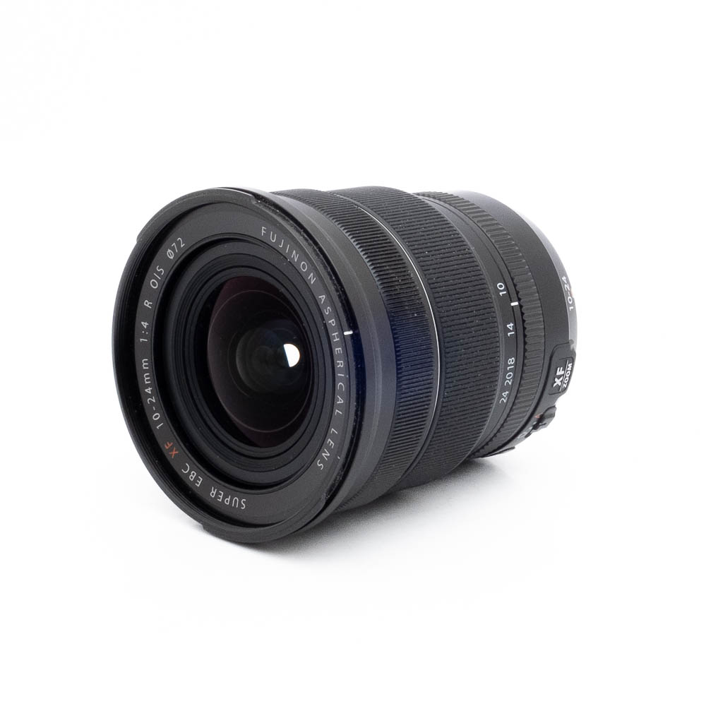 Fujinon 10-24mm f4 R OIS-2-3 Fujinon GF 50mm f/3.5 R LM WR (sis.ALV24%) - Käytetty -objektiivi on asetettu kyljelleen valkoista taustaa vasten, jolloin lasinen etuelementti ja reunan ympärillä olevat merkinnät tulevat esiin.