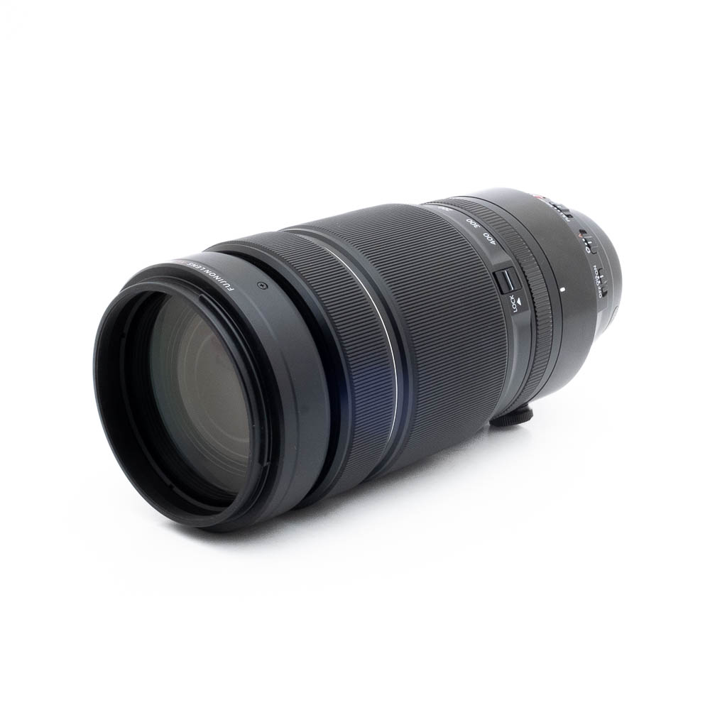 Fujinon 100-400mm f4-2 Fujinon GF 50mm f/3.5 R LM WR (sis.ALV24%) - Käytetty -objektiivi makaa kyljellään valkoista taustaa vasten, ja siinä näkyvät yksityiskohdat, kuten tarkennusrengas ja zoomausrengas, kytkimet ja objektiivin kiinnitys.
