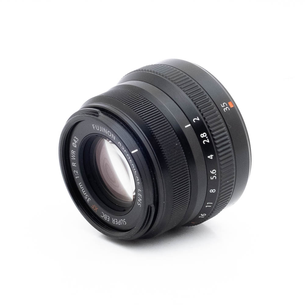 Fujinon 35mm f2 R WR-2 Musta Fujinon GF 50mm f/3.5 R LM WR (sis.ALV24%) - Käytetty -objektiivi näkyy valkoisella pohjalla, ja siinä on näkyvät tarkennusrenkaat ja aukkorenkaat sekä valkoiset kaiverretut merkinnät objektiivin yksityiskohdista ja mitoista.