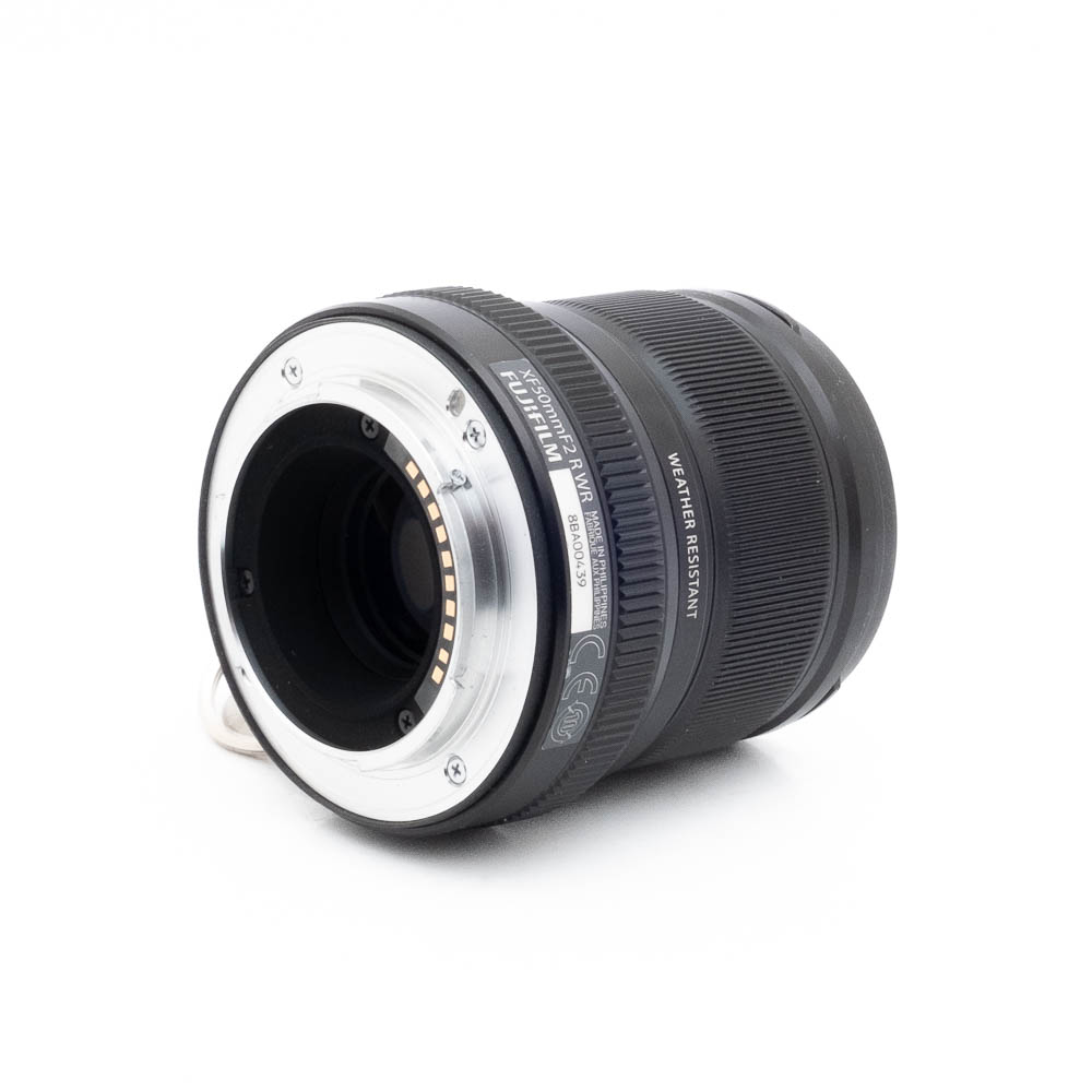 Lähikuva Fujinon GF 50mm f/3.5 R LM WR (sis.ALV24%) - Käytetty -objektiivista kyljellään, jossa näkyy metallinen objektiivin kiinnitys elektronisilla koskettimilla, kuvioidut pitorenkaat, tuotemerkinnät ja teksti "Weather Resistant".