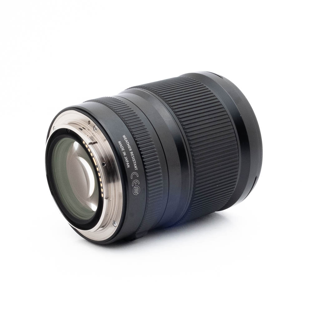 Fujinon GF 23mm f4 R LM WR-1 Fujinon GF 50mm f/3.5 R LM WR (sis.ALV24%) - Käytetty on musta kameraobjektiivi, jossa on uurrettu kahva ja metallinen kiinnitys, kuvassa kyljellään valkoista taustaa vasten. Objektiivin kontaktit ja sarjanumerot näkyvät takana.