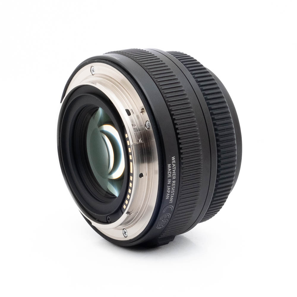 Fujinon GF 50mm f35 R LM WR-1 Lähikuva Fujinon GF 50mm f/3.5 R LM WR (sis.ALV24%) - Käytetty -objektiivista valkoisella taustalla, jossa korostuvat sen metallinen kiinnitys ja elektroniset kontaktit takapuolella.