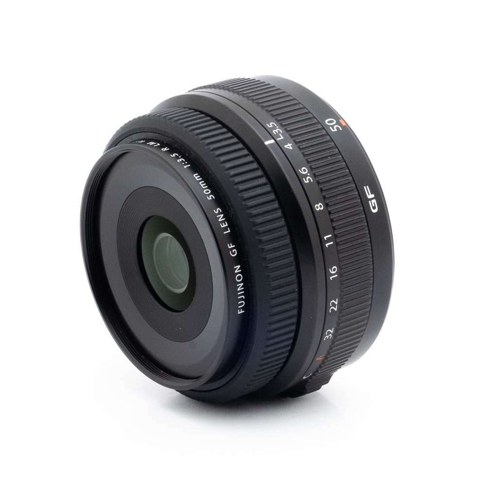 Fujinon GF 50mm f35 R LM WR-2 Fujinon GF 50mm f/3.5 R LM WR (sis.ALV24%) - Käytetty -objektiivi on kuvattu valkoisella taustalla, ja siinä näkyy tarkennusrengas ja aukkorenkaat, yksityiskohtaiset objektiivin merkinnät ja etulasi.