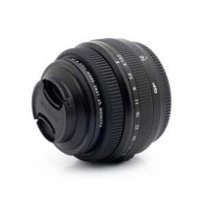 Fujinon GF 50mm f35 R LM WR-3 Fujinon GF 50mm f/3.5 R LM WR (sis.ALV24%) - Käytetty -objektiivi näkyy valkoisella taustalla, kun objektiivin suojus on kiinnitetty ja tarkennusrengas ja aukkorenkaat ovat näkyvissä.