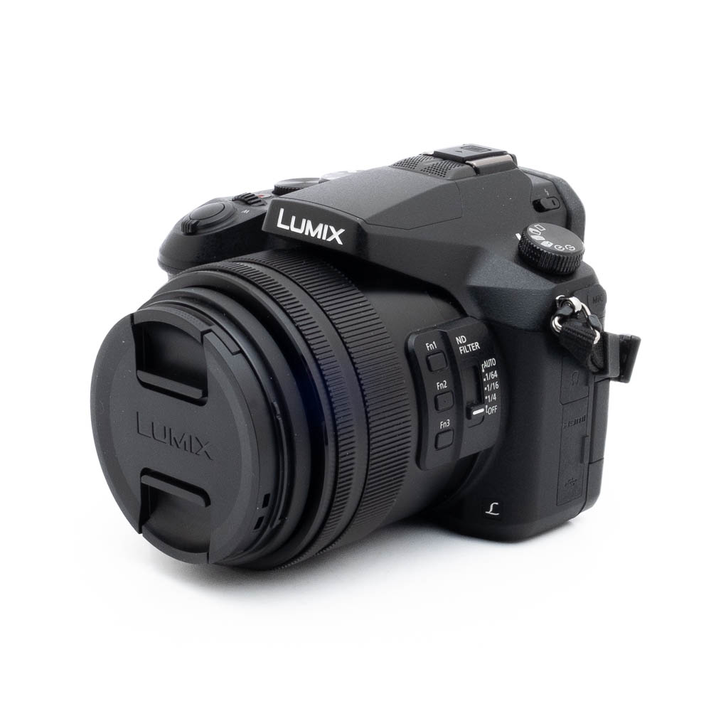 Lumix FZ-2000-4 Fujinon GF 50mm f/3.5 R LM WR (sis.ALV24%) - Käytetty -objektiivi on kuvassa suojus päällä, hieman vasemmalle kallistettuna valkoisella taustalla. Objektiivin rungossa näkyy erilaisia säätimiä ja painikkeita.