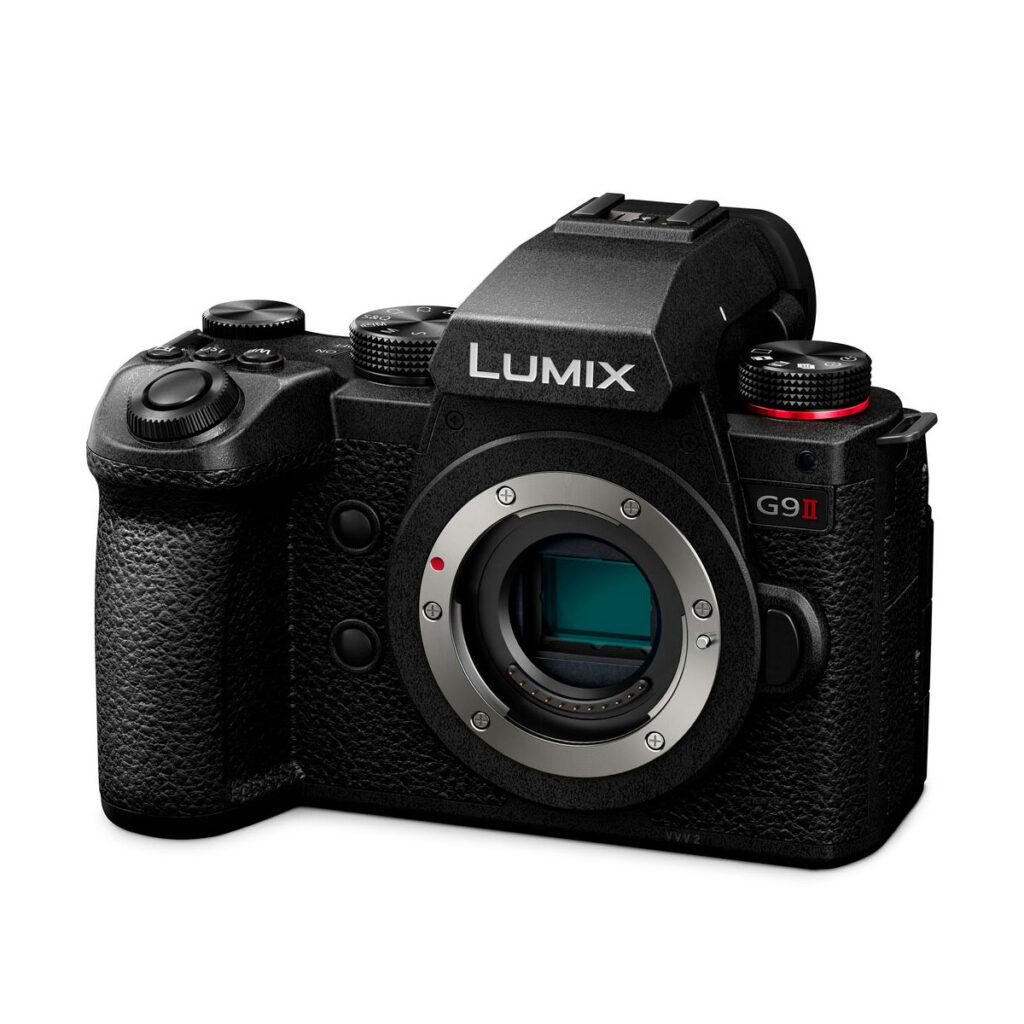 Lumix_G9II_001 Panasonic Lumix G9 II -järjestelmäkamera runko mustana, esittelee objektiivikiinnityksen, kuvioidun otepinnan sekä useita painikkeita ja säätimiä, LUMIX-logo etupuolella.