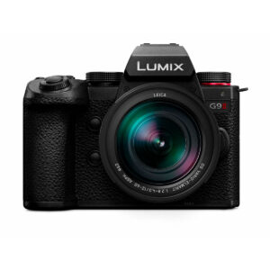 Lumix_G9II_12-60mm_002 Front view of the Panasonic Lumix G9 II + 12-60mm LEICA F2.8-4.0 Kit, featuring a black camera body with textured grip, visible control dials and a large light-reflecting Leica lens.