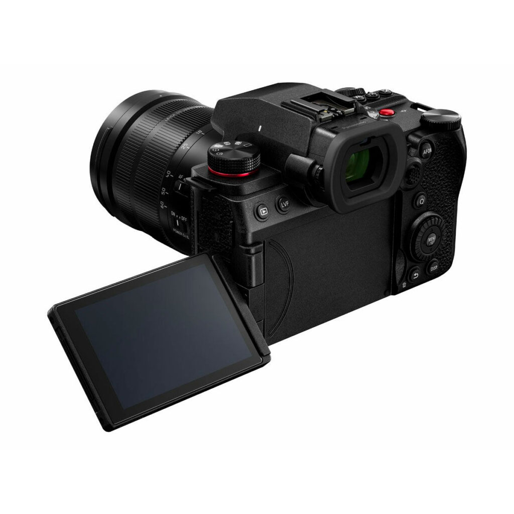 Lumix_G9II_12-60mm_006 Panasonic Lumix G9 II + 12-60mm LEICA F2.8-4.0 Kit -kamerassa on musta kamerarunko, jossa on suuri objektiivi, sivulle käännettävä LCD-näyttö, näkyvät takasäätimet, etsin sekä useita painikkeita ja valitsimia.