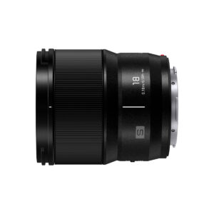 Lumix_S_18mm_003 Sivukuva Panasonic Lumix S 18mm f/1.8 -objektiivista, jossa on musta sylinterimäinen muotoilu, "18" ja "S" -merkinnät, kuvioitu rengas zoomausta tai tarkennusta varten ja oikealla puolella näkyvä metallinen kiinnitys.