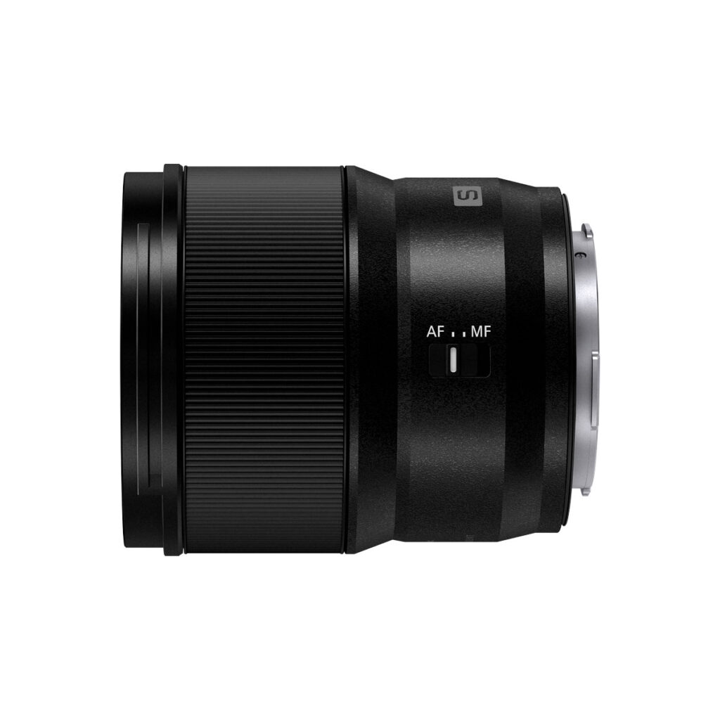 Lumix_S_35mm_004 A Panasonic Lumix S 35mm f/1.8 -objektiivi kuvattuna sivulta; mustasta rungosta erottuvat teksturoitu tarkennusrengas ja AF/MF-kytkin, taustana yksivärinen valkoinen.