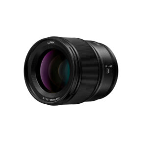 Lumix_S_85mm_001 A Panasonic Lumix S 85mm f/1.8 -objektiivi, musta runko, uritettu tarkennusrengas, näkyvät linssielementit ja AF/MF-kytkin, erillään valkoisella taustalla.