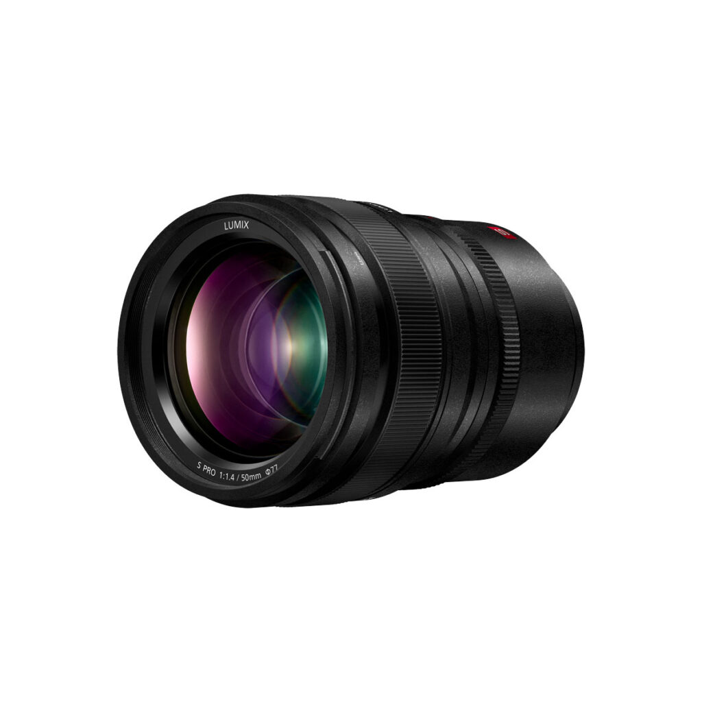 Lumix_S_Pro_50mm_002 Musta Panasonic Lumix S Pro 50mm f/1.4 -objektiivi, jossa on leveä etulasielementti ja näkyviä heijastuksia, esitetty valkoisella taustalla.